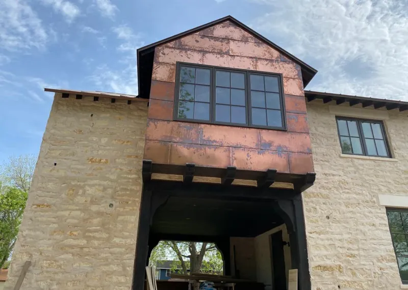 Copper metal panel facade on a stone building for Roof Repair in Albertville
